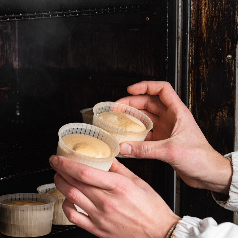 Le mani tolgono dal forno le vaschette di Affumicata appena affumicate